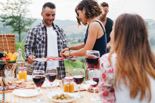 Group of friends doing a barbecue in the countryside - Millennials having fun together