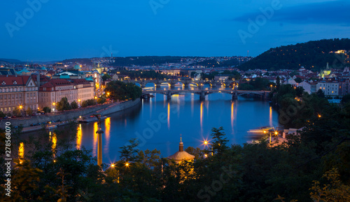 Night views of historical landmarks and the Vltava River.