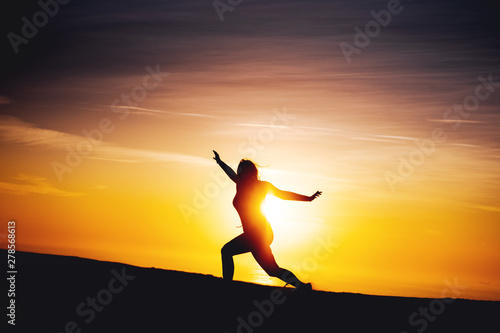 Fototapeta Naklejka Na Ścianę i Meble -  Side view of a active sport woman running at the beach with evening summer sunset light on relax sea vacations. Rubjerg Knude Lighthouse, Lønstrup in North Jutland in Denmark, Skagerrak, North Sea