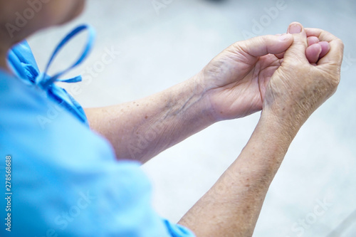 Asian senior or elderly old woman patient pain trigger finger lock her hand while sitting on bed in nursing hospital ward : healthy strong medical concept.