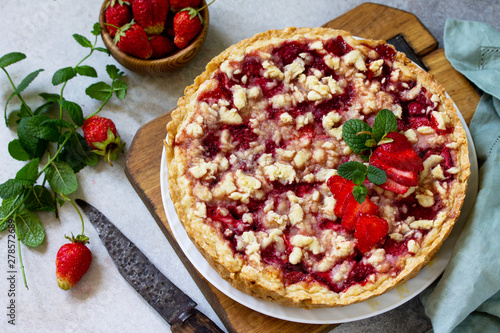 Delicious summer dessert strawberry pie with crumble, sweet delicious holiday cake with strawberry on a light stone or slate table.