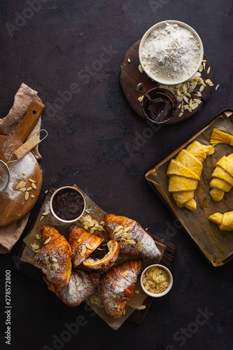 Breakfast croissant with almond flakes and icing sugar top view