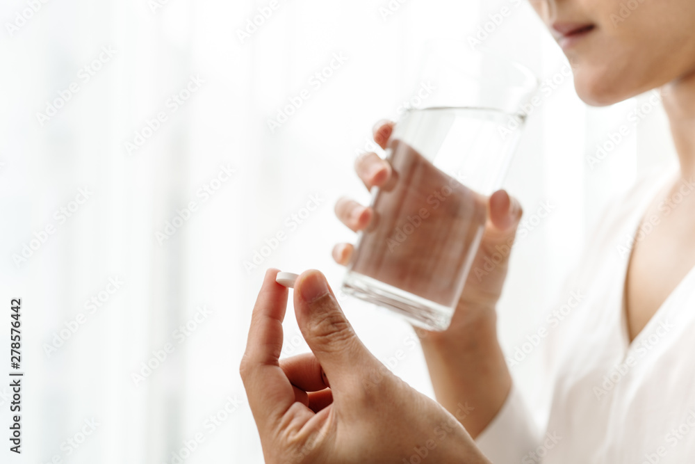 headache women hand hold medicine with a glass of water, healthcare and medicine recovery concept headache women hand hold medicine with a glass of water, healthcare and medicine recovery concept