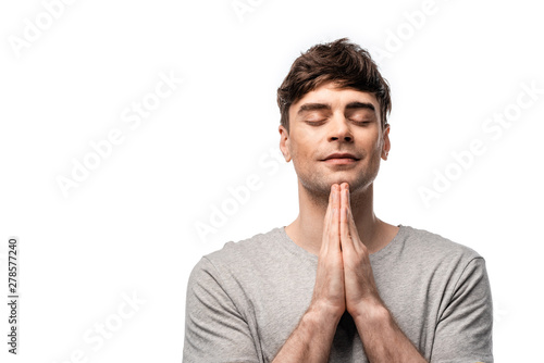 pensive man with closed eyes showing pray gesture and smiling isolated on white