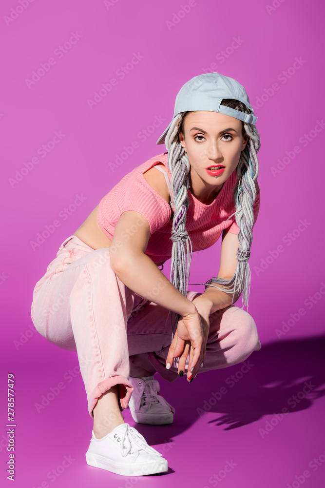 beautiful stylish girl with dreadlocks in hat posing on purple beautiful stylish girl with dreadlocks in hat posing on purple