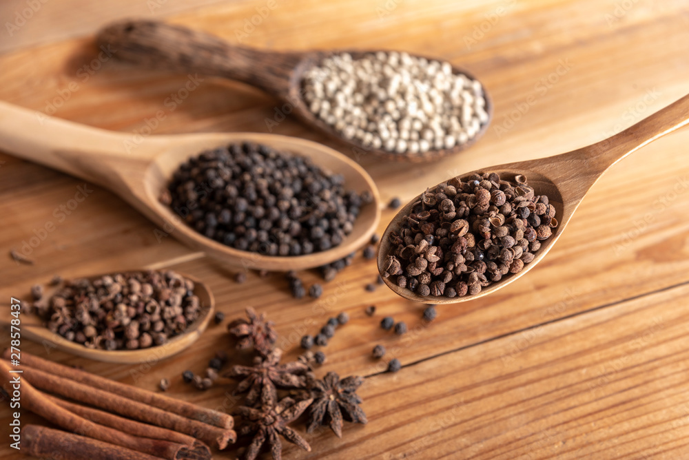 close up chille pepper in wooden spoon surround with spice powder on wooden table close up chille pepper in wooden spoon surround with spice powder on wooden table