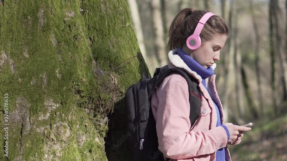 Traveler girl in the forest with mobile phone Traveler girl in the forest with mobile phone