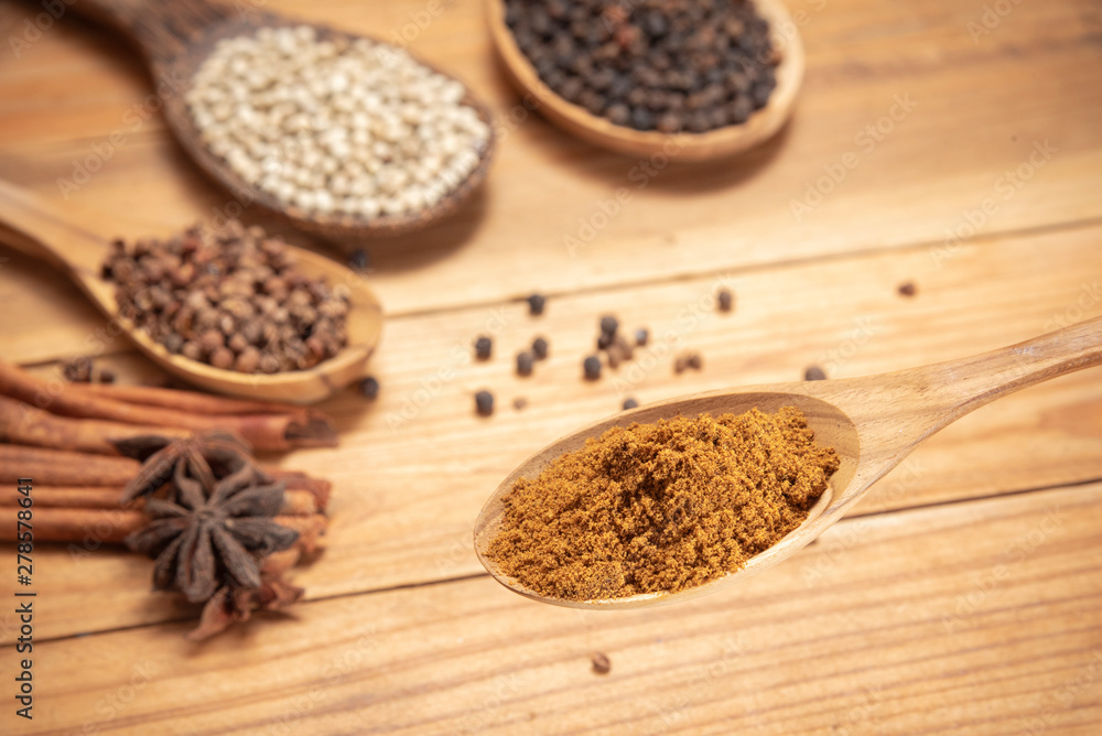 close up Spices Powder in wooden spoon surround with spice powder on wooden table close up Spices Powder in wooden spoon surround with spice powder on wooden table