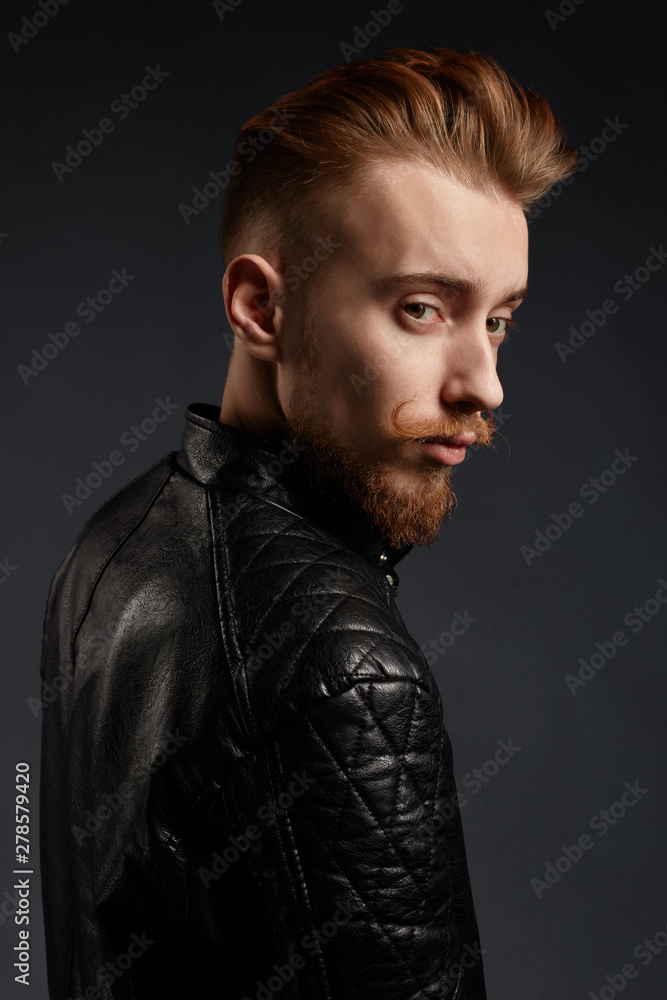 awesome gorgeous model in trendy clothes posing to the camera. close up portrait.isolated black background