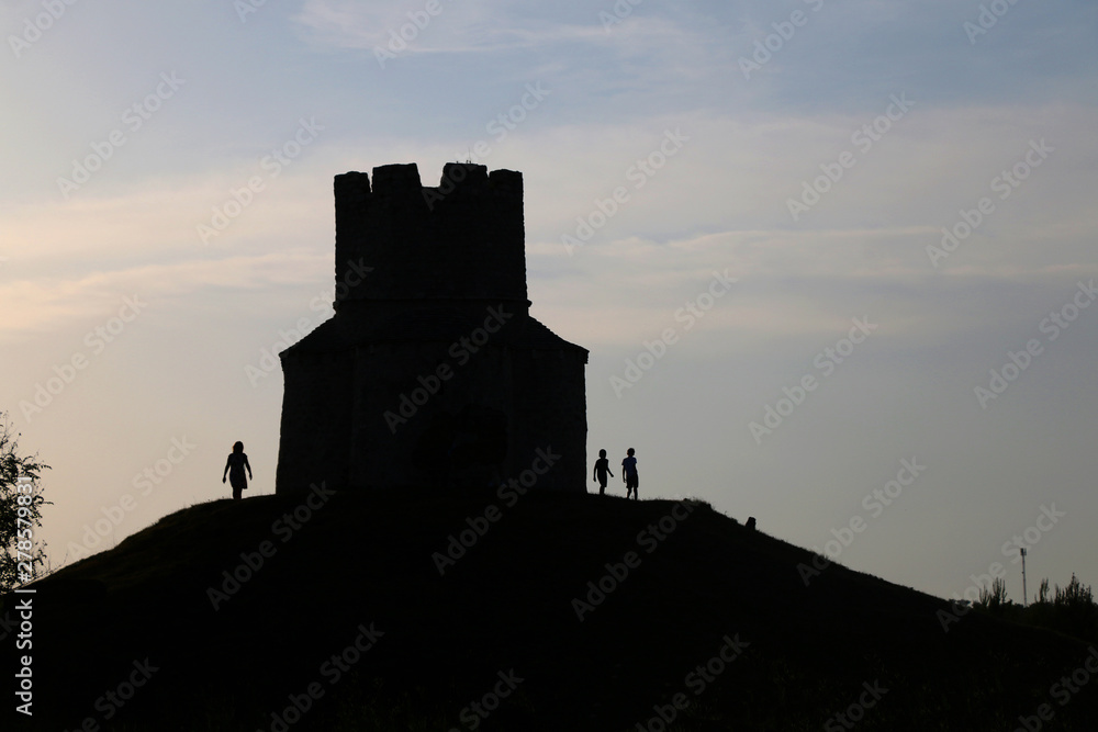 Silhouette of small medieval church of St. Nicholas and visitors around, near Nin, Croatia.