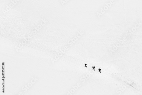 Three lonely isolated climbers climbing a mountain in French Alps near Chamonix