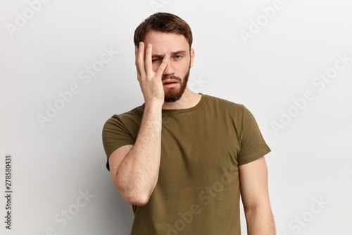 Young handsome dissapointed unhappy depressed tired man covering his eyes and face with palm, being fed up of working, tiredness, depression. isolated white background. studio shot