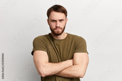 angry sad unhappy serious man with disapproving expression on face and crossed arms looking at the camera. close up portrait. isolated white background. negative emotion