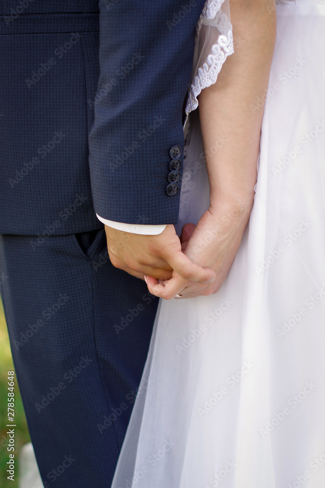 The hands of the bride and groom. Hands in the lock. The groom holds the hand of the bride tightly. Wedding day The hands of the bride and groom. Hands in the lock. The groom holds the hand of the bride tightly. Wedding day