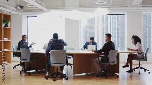 Group Of Business Professionals Meeting Around Table In Modern Office
