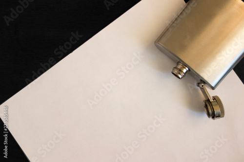 Mock up flat lay of empty sheet of paper and open empty flask on the table. Problems with alcohol addiction and further psychology depression. Letter note or message copy space to describe
