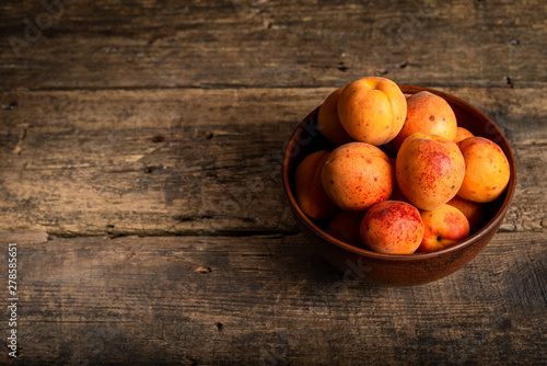fresh apricots in a basket on a wooden table