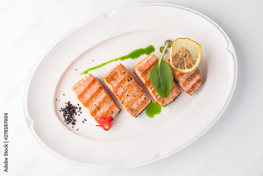 Grilled fish fillet salmon. Selected pieces of red fish. Seafood. Banquet festive dishes. Fine dining restaurant menu. White background.