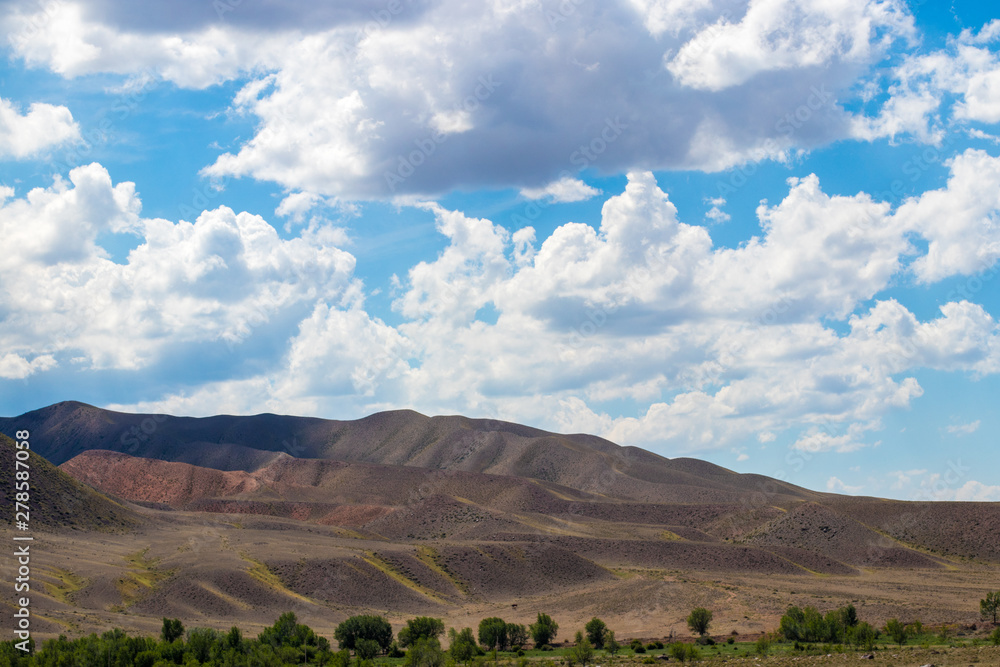 Fototapeta premium Steppe landscapes of Kazakhstan. Sky with clouds over the mountains