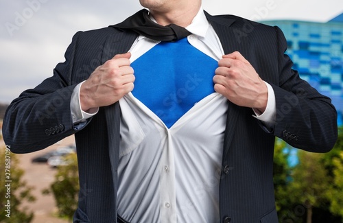 Businessman tears shirt on himself to show that he is Superman isolated on background