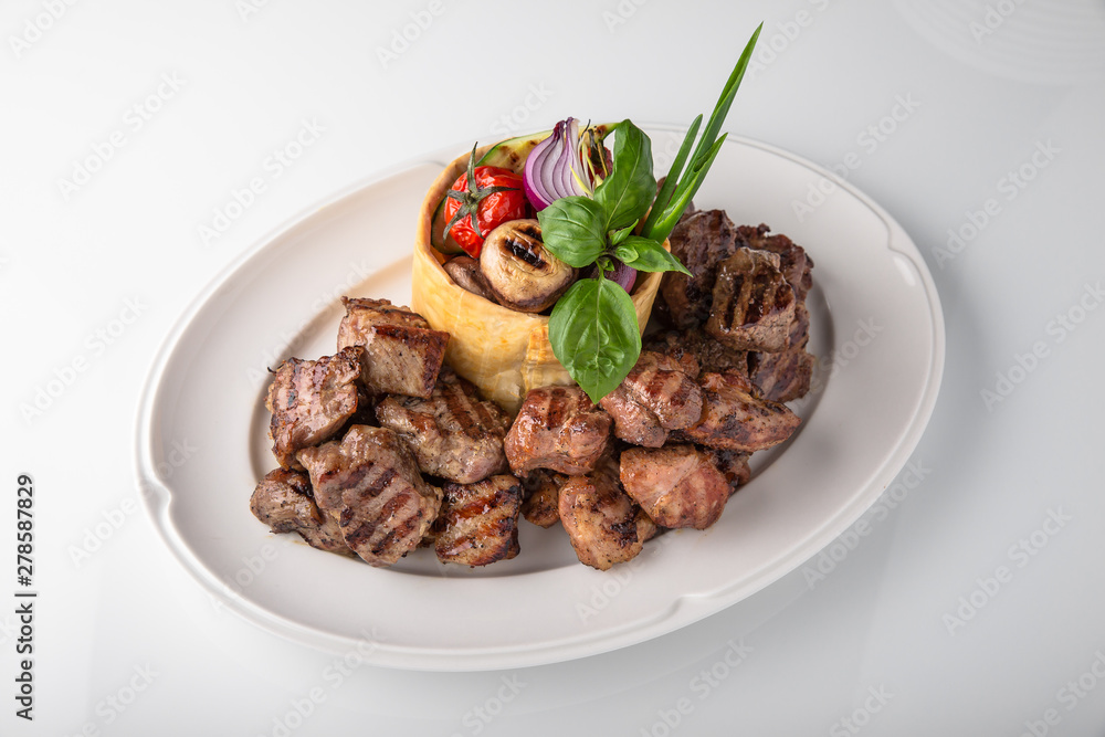 Skewers of pork, beef with vegetables and mushrooms. Grilled meat. Banquet festive dishes. Fine dining restaurant menu. White background. Skewers of pork, beef with vegetables and mushrooms. Grilled meat. Banquet festive dishes. Fine dining restaurant menu. White background.