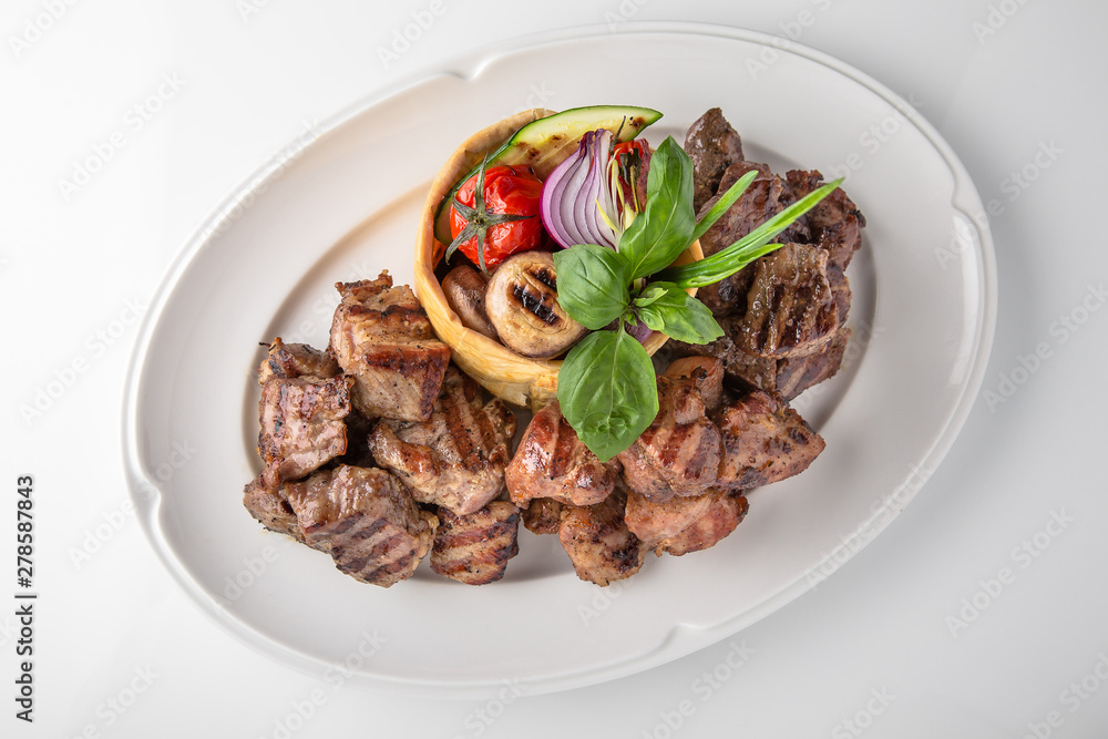 Skewers of pork, beef with vegetables and mushrooms. Grilled meat. Banquet festive dishes. Fine dining restaurant menu. White background. Skewers of pork, beef with vegetables and mushrooms. Grilled meat. Banquet festive dishes. Fine dining restaurant menu. White background.