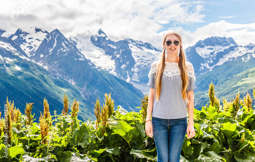 Blonde girl with long hair on vacation in the resort of Dombai in the summer, summer vacation in the mountain resort of the Caucasus