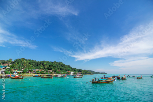 Traditional Thai fishing boats wrapped with colored ribbons. Against the backdrop of a tropical island