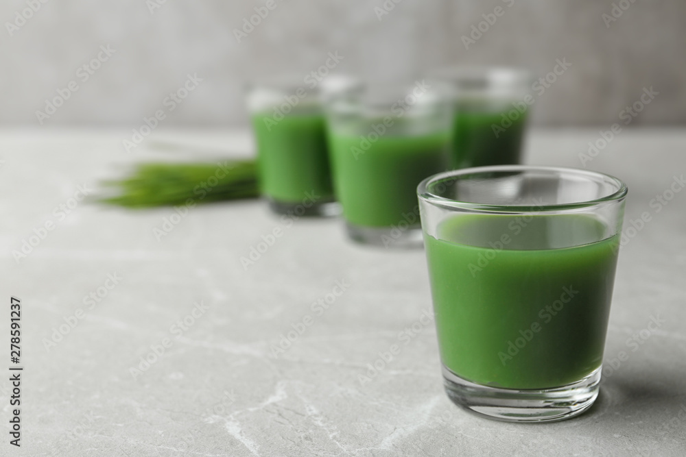 Glass of wheat grass juice on marble table. Space for text Glass of wheat grass juice on marble table. Space for text