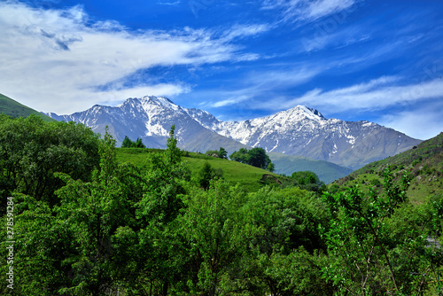 Beautiful view of alpine meadows in the Caucasus mountains. Pastures  meadows on the slopes and snow-capped mountains.