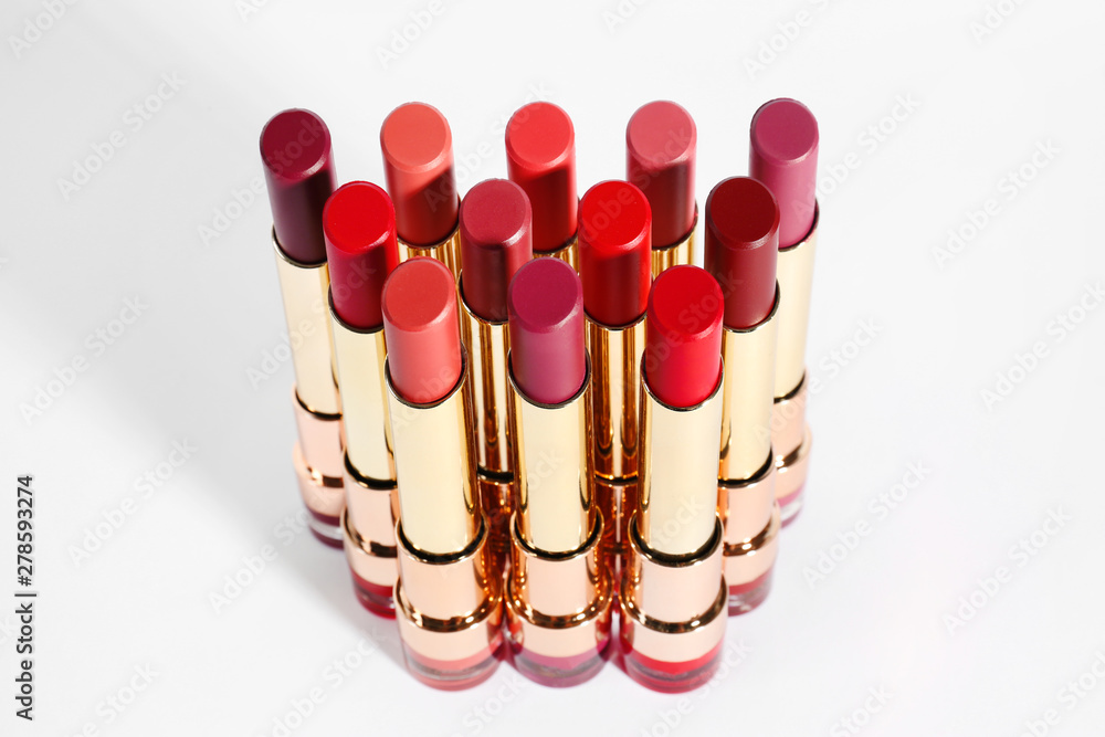 Set of bright lipsticks in gold tubes on white background Set of bright lipsticks in gold tubes on white background