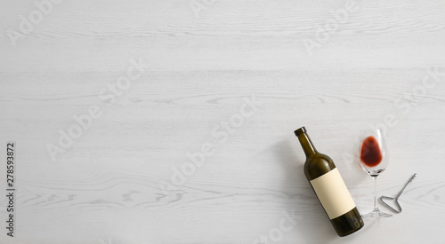 Photos Flat lay composition with bottle of wine and elegant glass on white wooden background