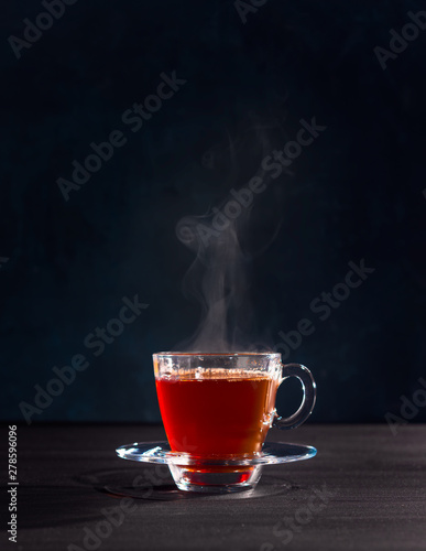 Freshly brewed black tea in a transparent glass Cup,escaping steam