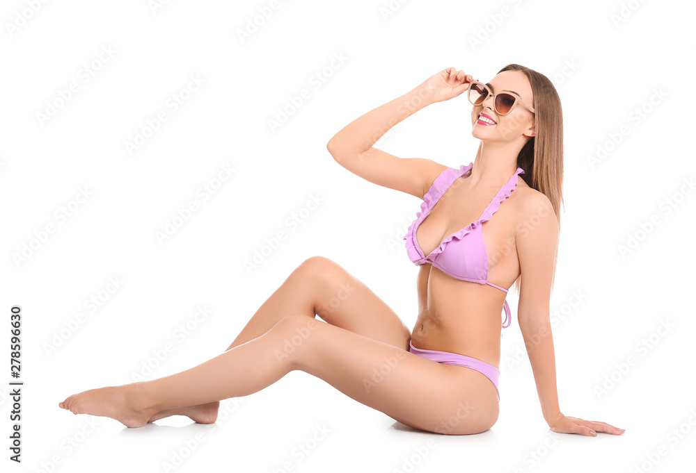 Pretty sexy woman with beautiful slim body in stylish bikini sitting on white background