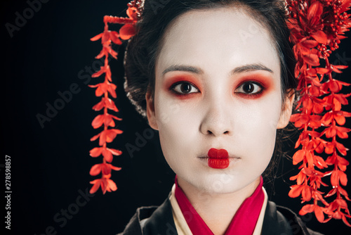 Canvas-taulu portrait of beautiful geisha in black and red kimono and flowers in hair isolate