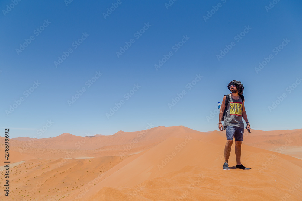 Homme debout dans le désert sur une dune de sable