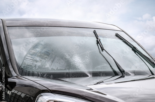 Canvas-taulu Washing car windscreen with wipers and liquid, closeup