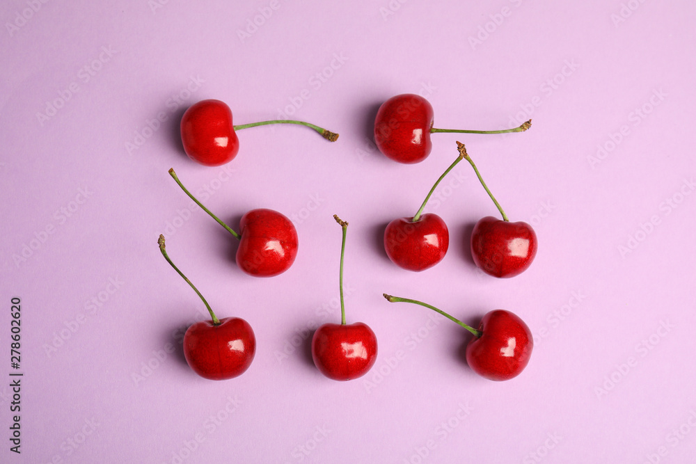 Many ripe sweet cherries on lilac background, flat lay Many ripe sweet cherries on lilac background, flat lay