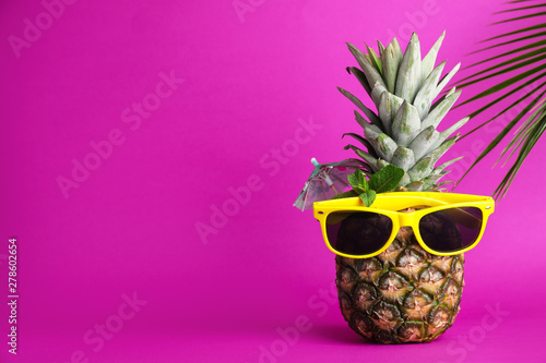 Fresh pineapple with sunglasses, umbrella and mint as summer cocktail on color background, space for text