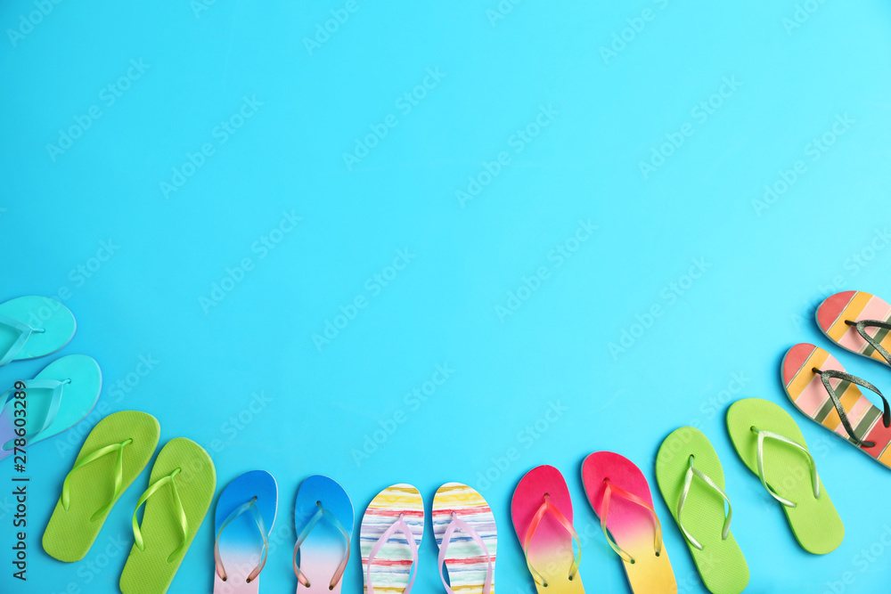 Different flip flops and space for text on blue background, flat lay. Summer beach accessories