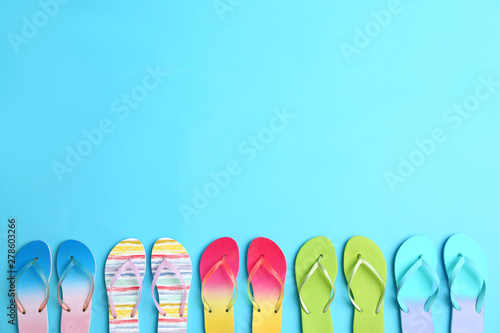 Different flip flops and space for text on blue background, flat lay. Summer beach accessories © New Africa