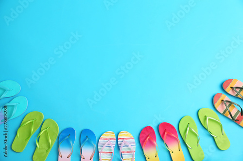 Different flip flops and space for text on blue background, flat lay. Summer beach accessories