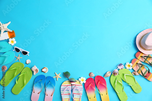 Flat lay composition with different flip flops on blue background, space for text. Summer beach accessories