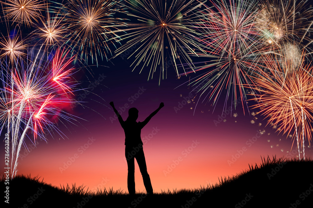 Silhouette of young woman cheerful with happy new years firework display background. Conceptual image of freedom and successful in New year. Silhouette of young woman cheerful with happy new years firework display background. Conceptual image of freedom and successful in New year.