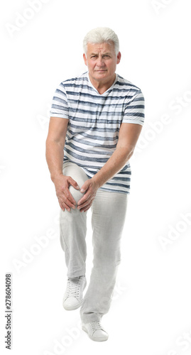Full length portrait of senior man having knee problems on white background