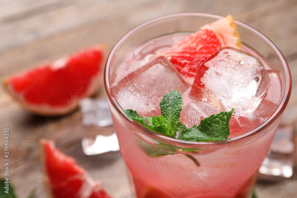 Glass of refreshing drink with grapefruit and mint on wooden table, closeup view. Space for text Glass of refreshing drink with grapefruit and mint on wooden table, closeup view. Space for text