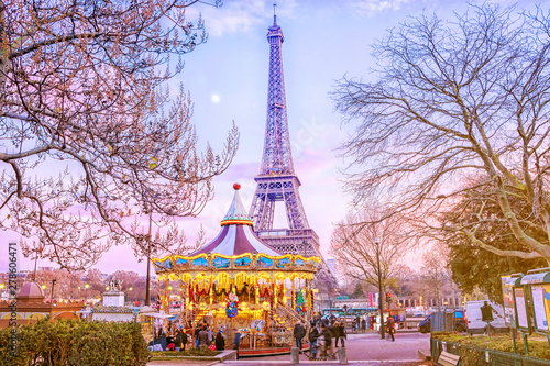 The Eiffel Tower and vintage carousel on a winter evening in Paris, France. © MarinadeArt