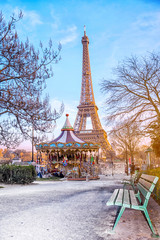 The Eiffel Tower and vintage carousel on a winter evening in Paris, France.