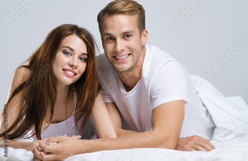 Young attractive happy couple on the bed