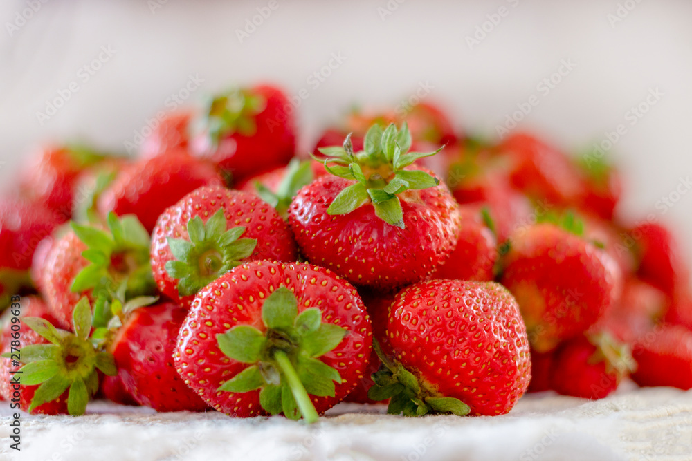 Lots of fresh ripe red strawberries on the white table. Home garden harvesting Lots of fresh ripe red strawberries on the white table. Home garden harvesting